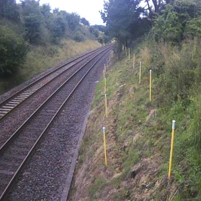 Tilt sensors mounted on poles for monitoring a railway slope